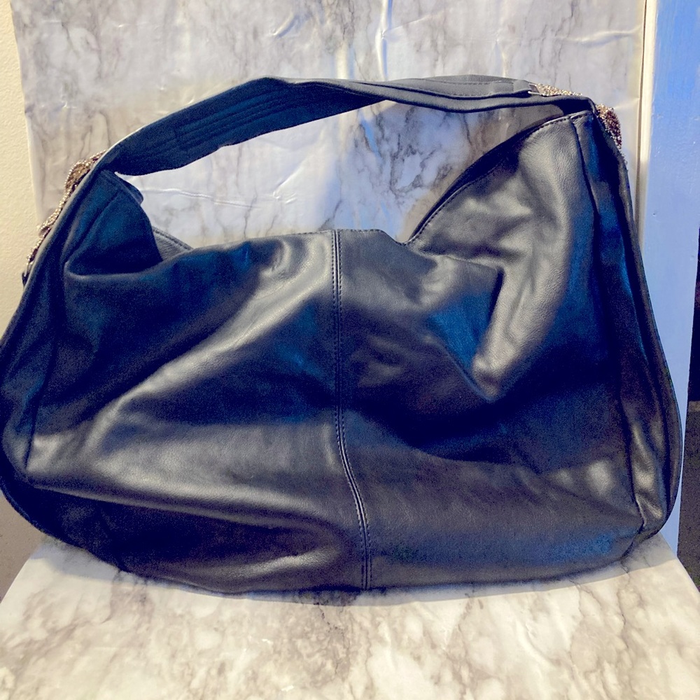 Black faux leather hobo with a decorative sides.